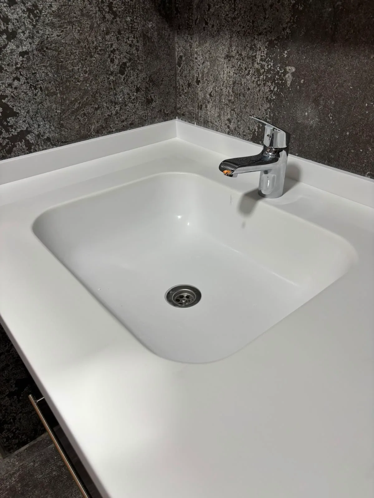 Köşeli formda entegre akrilik lavabo ve tezgah detayı